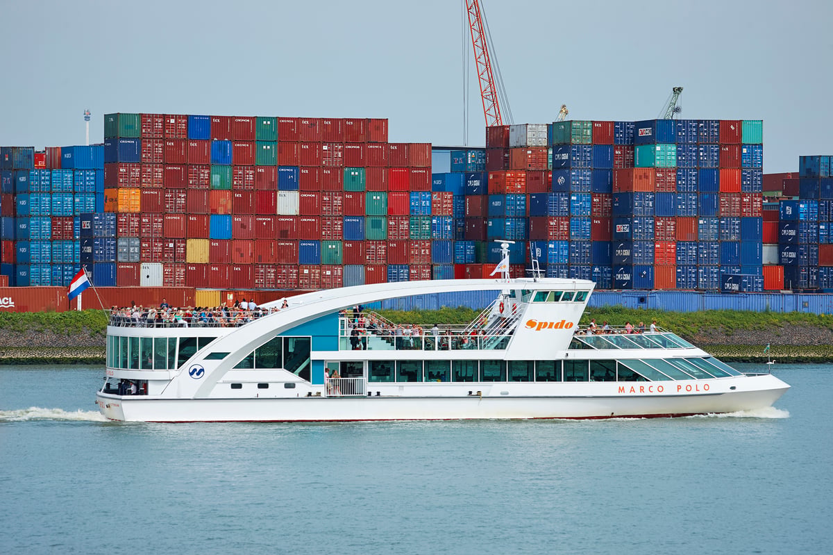 Spido-rondvaartboot vaart tussen grote containerschepen en containerterminals in de Rotterdamse haven